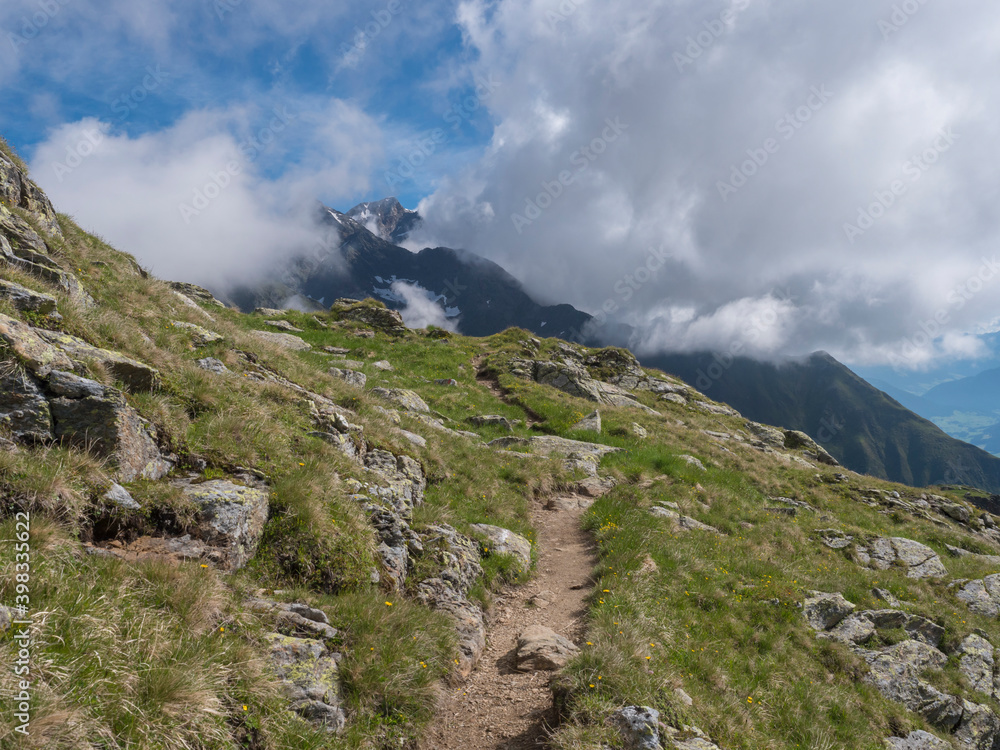 Summer alpine mountain landscape with footpath of Stubai hiking trail and snowy mountain peaks, Stubai Hohenweg, Tyrol Alps, Austria Summer alpine mountain landscape with footpath of Stubai hiking trail and snowy mountain peaks, Stubai Hohenweg, Tyrol Alps, Austria