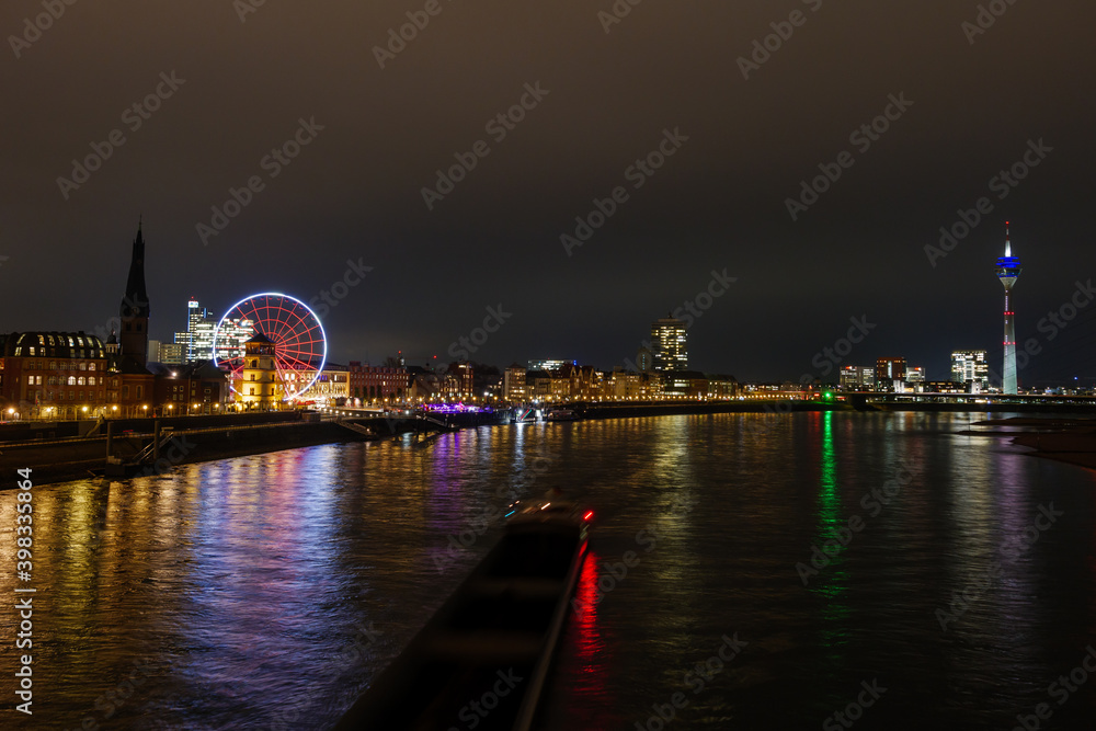 High angle, outdoor night scenery over riverside of Rhine River and street with light of traffic movement in Düsseldorf, Germany.