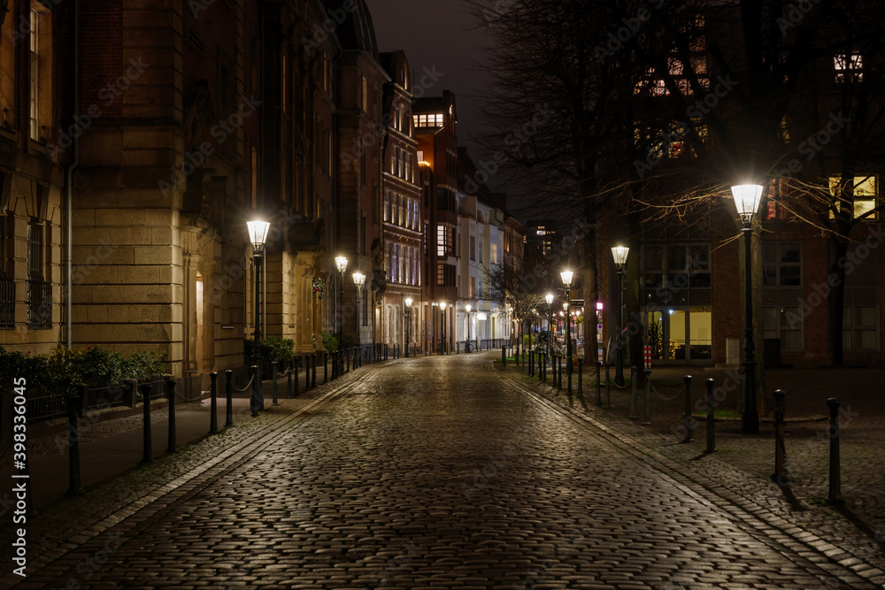 Düsseldorf, Germany - NOVEMBER 2020:Night scenery silent walking street with closed shop, cafe and restaurant in old town during lockdown from epidemic COVID-19 in Düsseldorf, Germany.