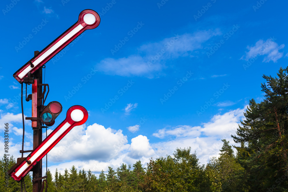 Railroad Travel Departure Concept / Old nostalgic go ahead railway signal at nature above treetops and blue sky background for your text (copy space)
