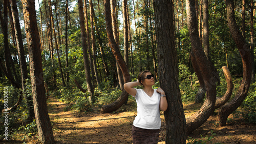 Zachwycona dziewczyna podziwia pomnik przyrody o nazwie Krzywy Las znajdujący się w województwie Zachodniopomorskim nieopodal miejscowości Nowe Czarnowo, Polska photo