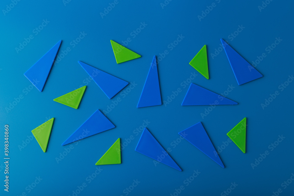 Abstract duotone flat lay with green and blue triangles on blue background Abstract duotone flat lay with green and blue triangles on blue background