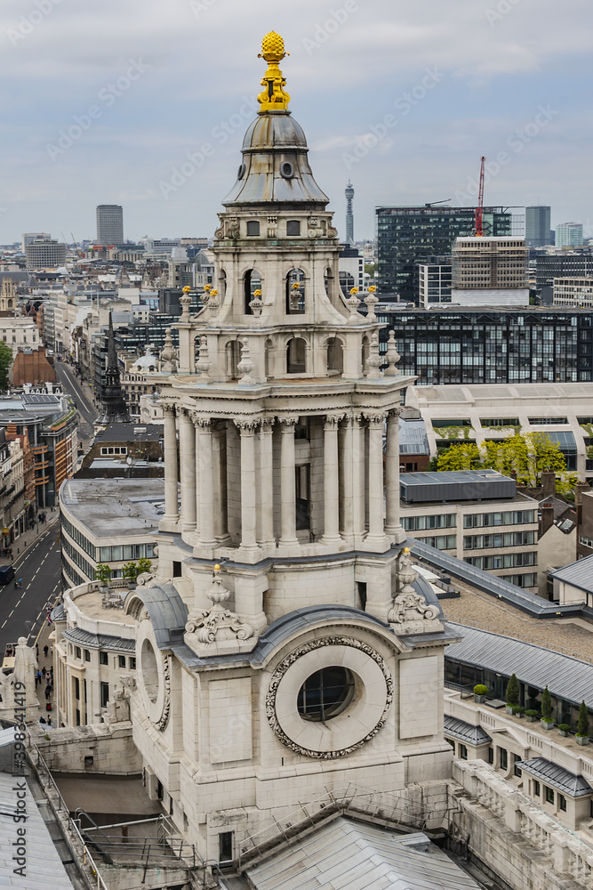 View of the tower of magnificent St. Paul Cathedral against the background of the city quarters of London from dome of St. Paul Cathedral. London, UK.
