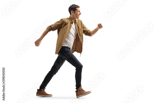 Full length profile shot of a casual man in jeans and shirt running