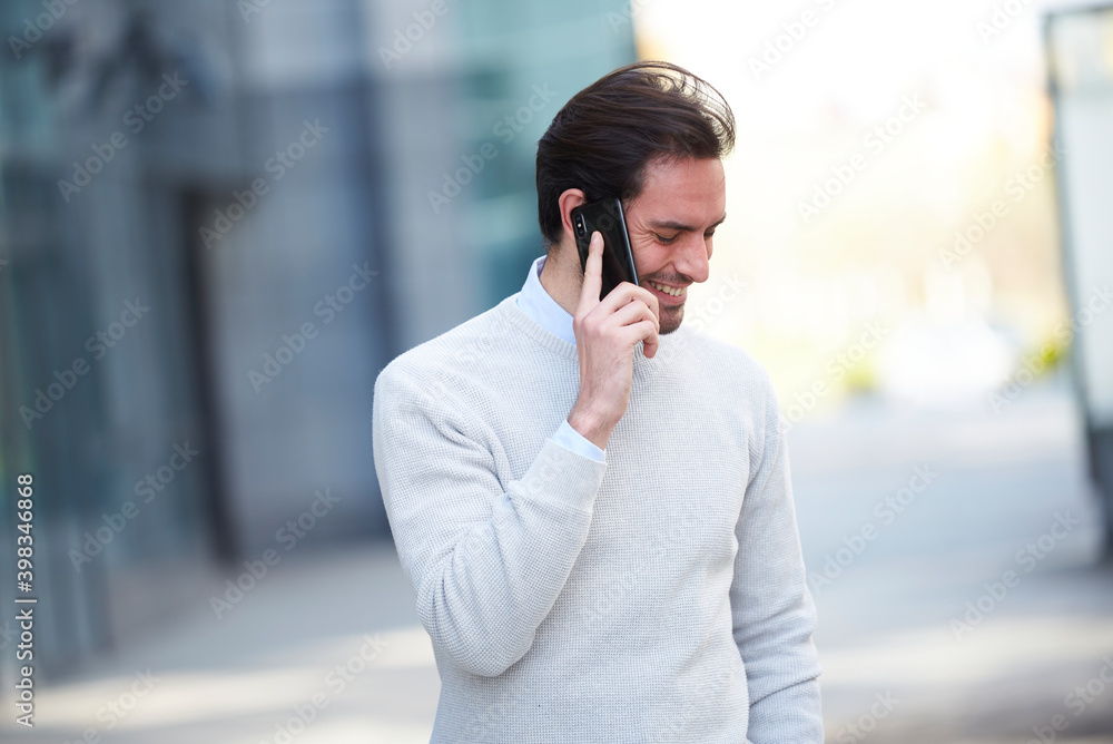 Single casual male chats on his mobile, walking outside Single casual male chats on his mobile, walking outside