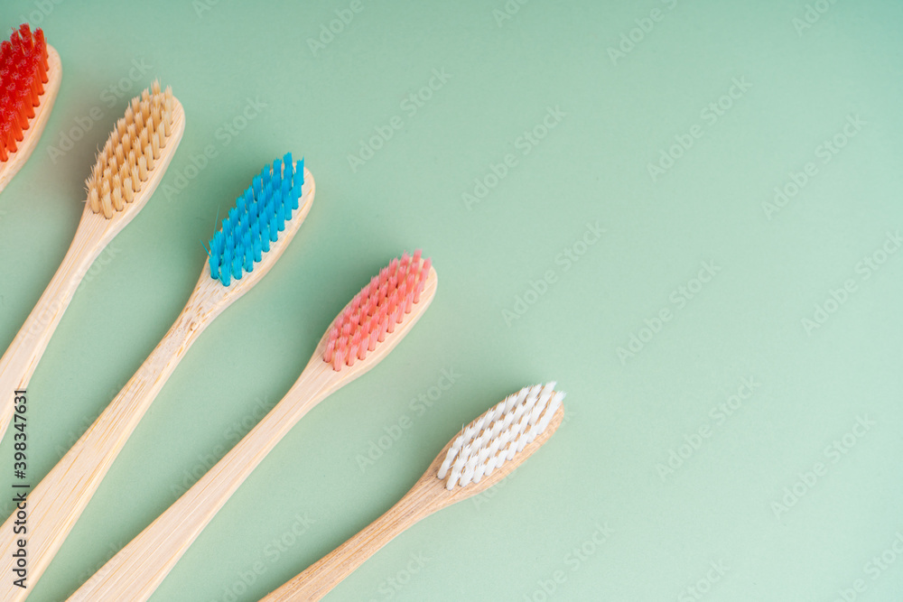 A set of Eco-friendly antibacterial toothbrushes made of bamboo wood on a light green background. Environmental care trends A set of Eco-friendly antibacterial toothbrushes made of bamboo wood on a light green background. Environmental care trends
