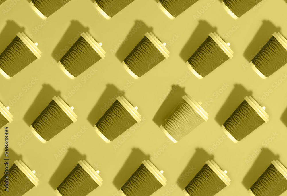 Pattern of many gray paper coffee cups with plastic covers on illuminating yellow as color trend of the year 2021. Pattern of many gray paper coffee cups with plastic covers on illuminating yellow as color trend of the year 2021.
