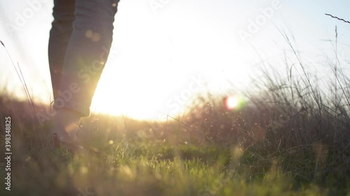 Sunset in the field – young woman walking through away to the sunset sunlight. Video of Bugaz Spit, Anapa – Russia green grass. photo