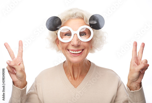 Photo of good mood happy smiling positive old woman show v-sign wear big sunglasses