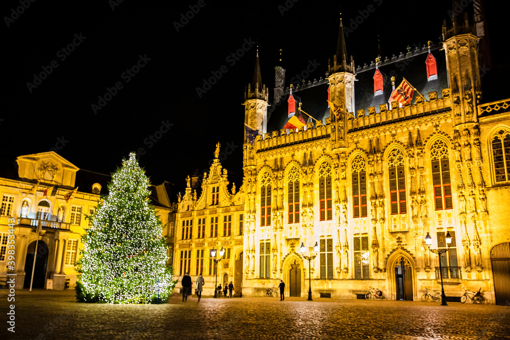 Christmas tree on Burg square and City Hall in Bruges, Belgium. Festive lights and decorations.