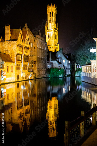 Historical city center in Bruge at night, Belgium. Old medieval buildings reflect in the water. Christmas.