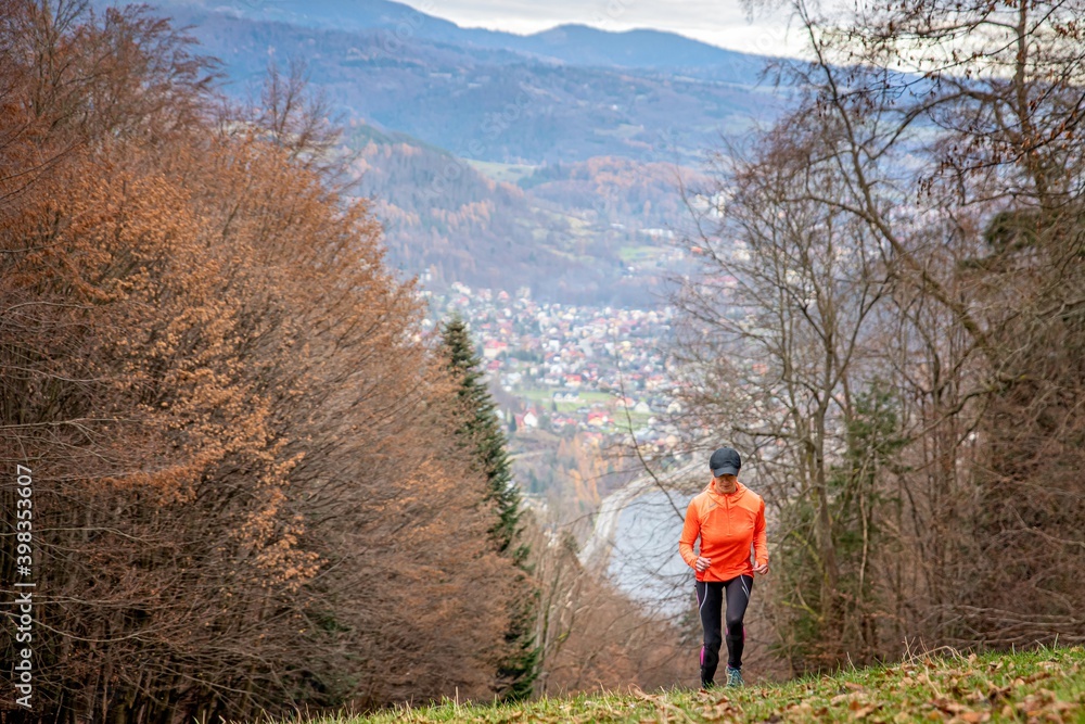Woman runner runs uphill. Training in the mountains.