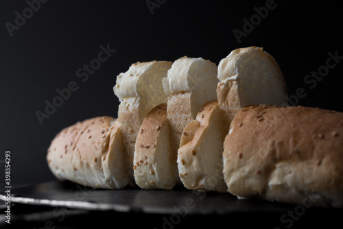 Fresh bread sliced baguette in black background