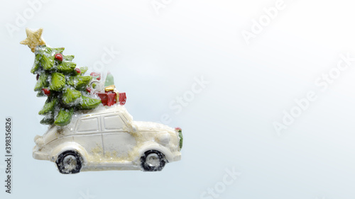 Christmas background with car toy, the car carries the Christmas tree and gifts, close-up. With copy space. © Uixdk