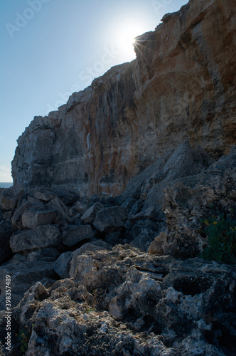 starry sun, on cliff, limestone rock, with blue sky, rockfall,