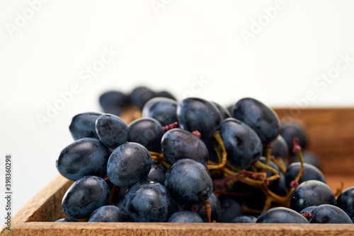 Wallpaper Mural Dark red grapes lie in a box made of mango wood on a white background.Isolate. Torontodigital.ca