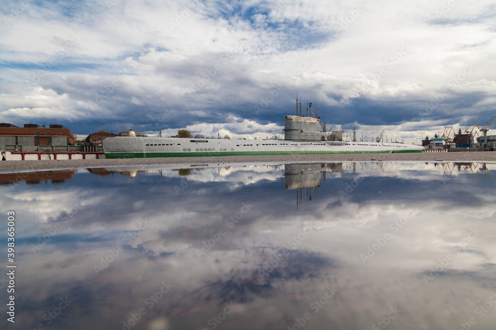 Old soviet submarine in port reflected in puddle