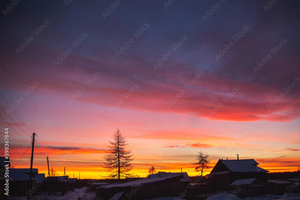 Old russian village houses in the bitter cold. Winter dusk landscape..