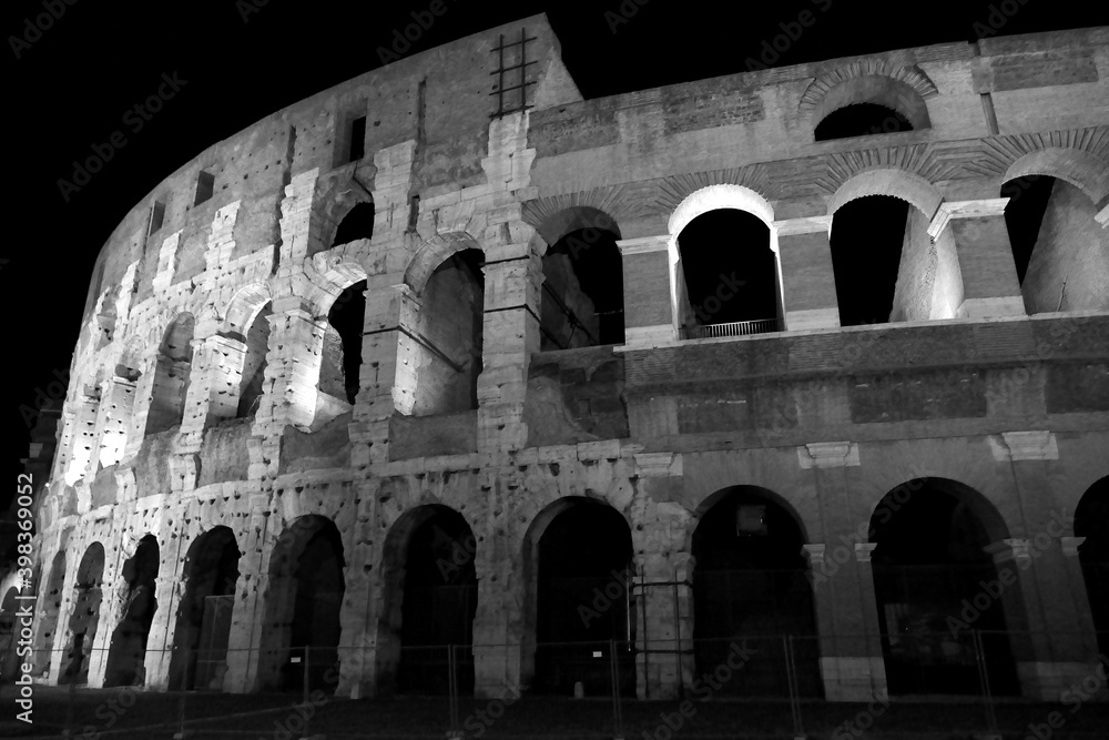 The monuments of rome in black and white at night.	