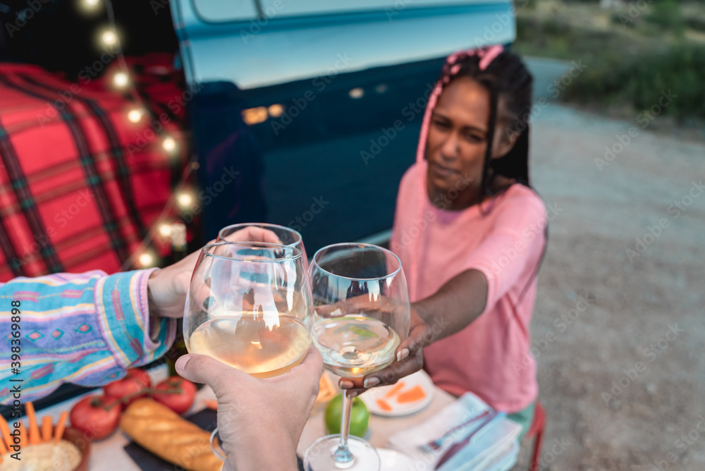 Multiracial friends cheering with white wine and celebrating outdoors in caravan - Focus on glasses Multiracial friends cheering with white wine and celebrating outdoors in caravan - Focus on glasses