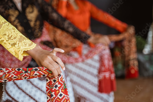 portrait young woman presenting traditional Javanese dance movements being hold shawl