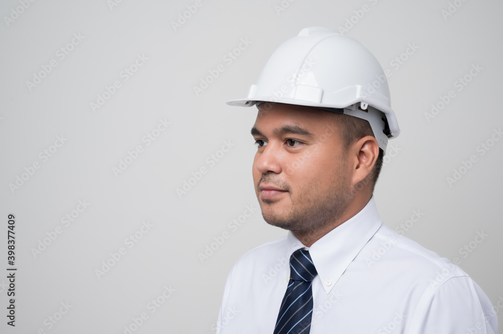 Smiling young asian civil engineer wearing helmet hard hat standing on isolated white background. Mechanic service concept. Smiling young asian civil engineer wearing helmet hard hat standing on isolated white background. Mechanic service concept.