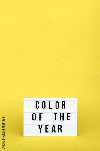Retro lightbox with Color of the year wording on the trendy solid yellow backdrop in vertical format, place for text