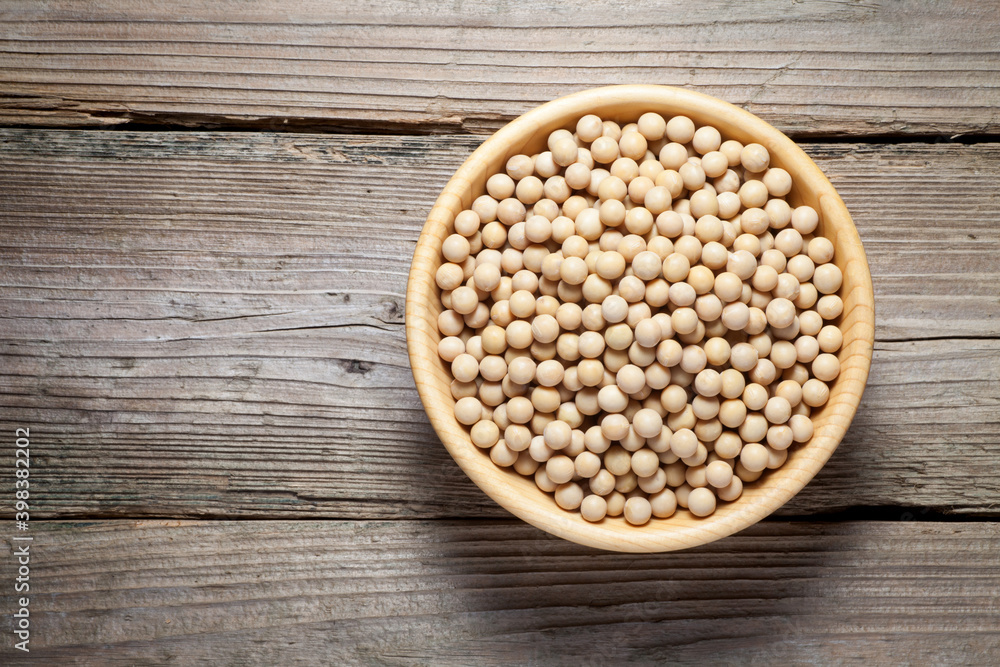 Soybean seeds in a wooden bowl on old wood. Top view. Soybean seeds in a wooden bowl on old wood. Top view.