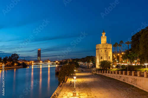 view of seville in spain in blue hour - golden tower and the river guadalquivir