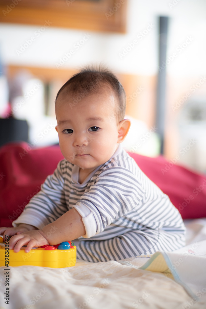 Asian infant baby sitting and playin on the bed after wake up in the morning Asian infant baby sitting and playin on the bed after wake up in the morning