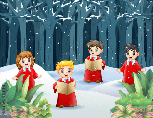 Group of kids in red costume singing Christmas carols on the snowy forest