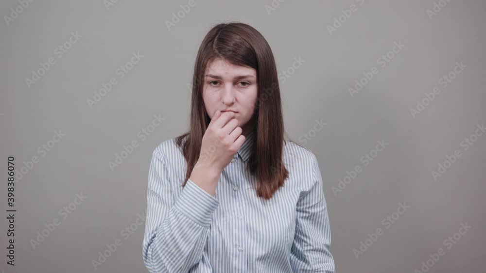 Contact lens on index finger, pointing to eye with hand, thinking, having sensitive eyes, touching herself face by forefinger. Young attractive woman, dressed blue shirt with brown eyes, brunette hair Contact lens on index finger, pointing to eye with hand, thinking, having sensitive eyes, touching herself face by forefinger. Young attractive woman, dressed blue shirt with brown eyes, brunette hair