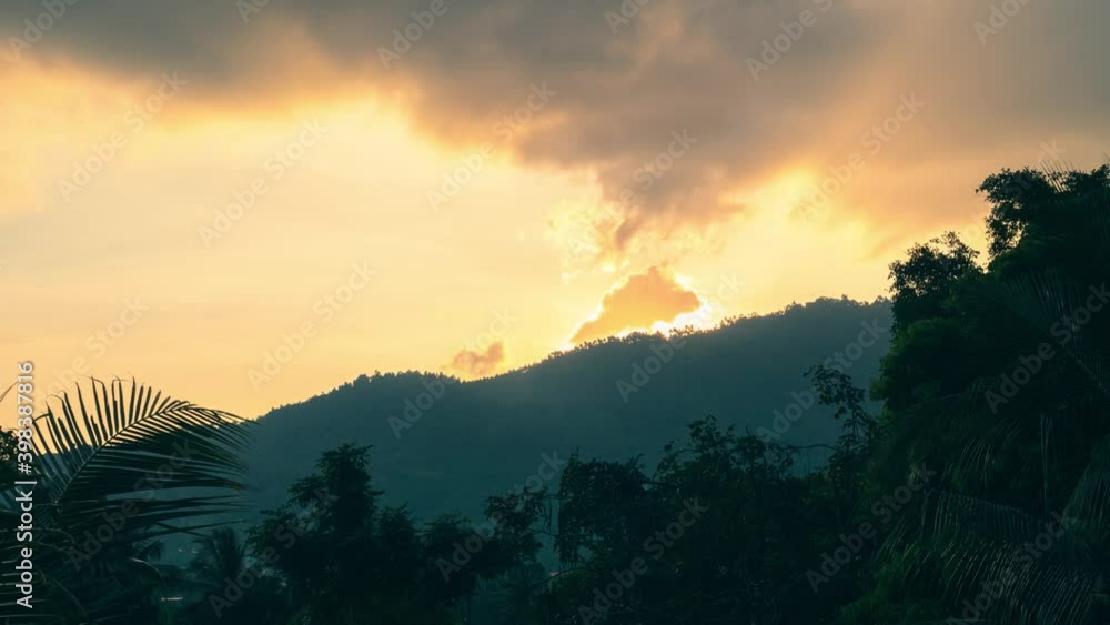 Sun rising from behind the mountain top over the valley with forest and palm trees on a tropical island.4k time-lapse Sun rising from behind the mountain top over the valley with forest and palm trees on a tropical island.4k time-lapse