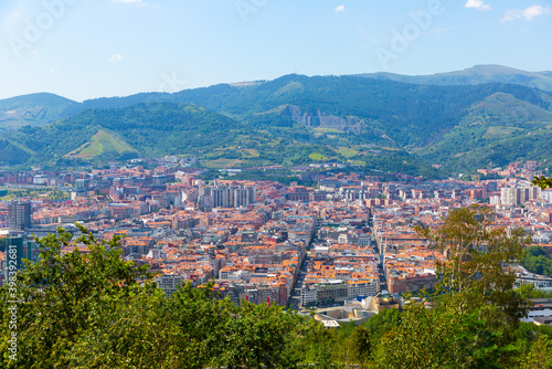 Scenic panoramic view of modern Bilbao cityscape surrounded by mountain ranges in summer  Spain ..