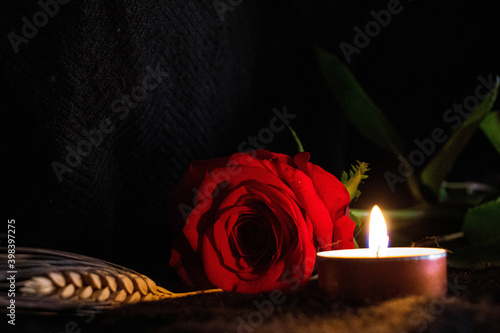 Rosa roja con fondo negro y vela photo