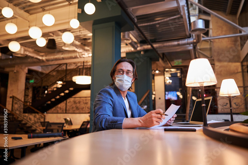 Mindful citizen using protective mask in public co-working lounge