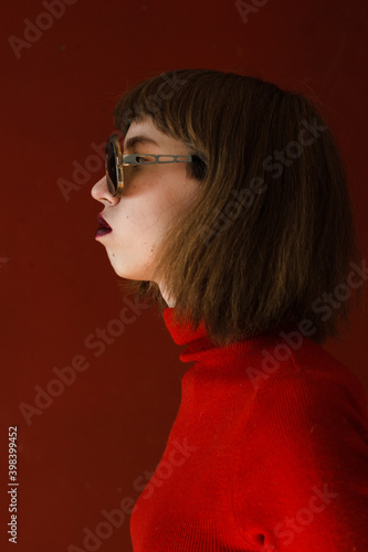 Young woman with make-up in  sunglasses and red headscarf on red background. copy space for text