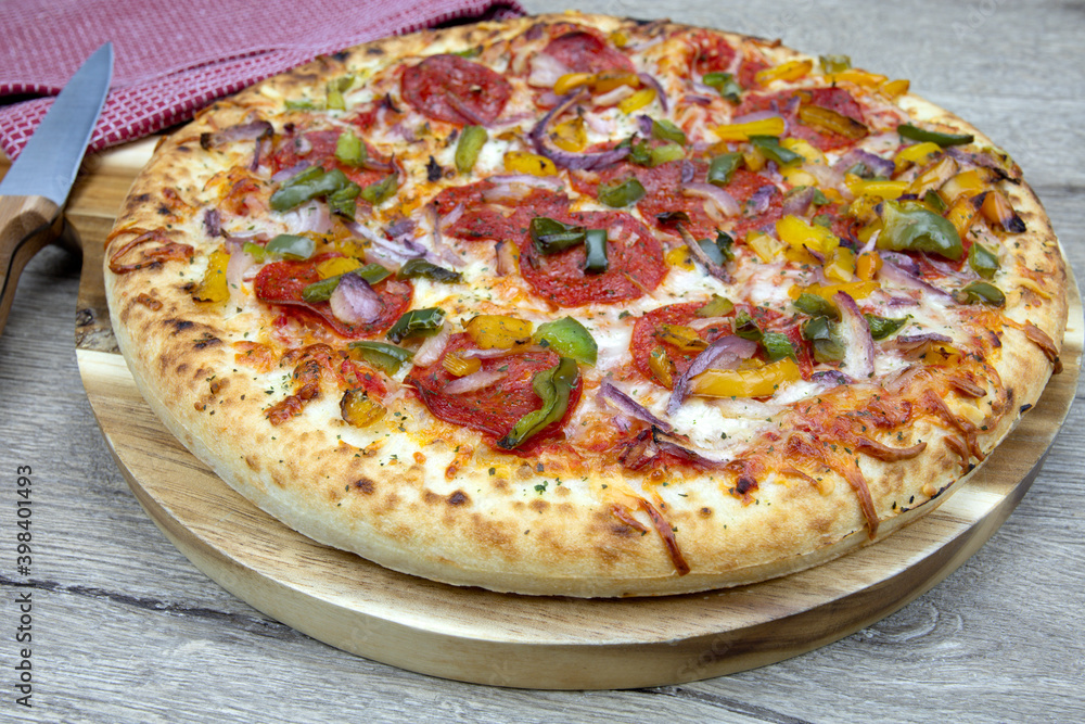 pizza au chorizo, poivrons et oignons rouges sur une table