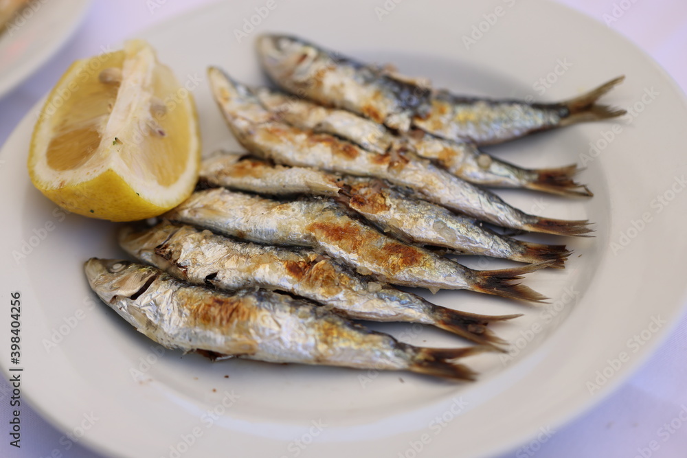 Malaga spits with lemon slice in macro scale. Sardines Malaga spits with lemon slice in macro scale. Sardines