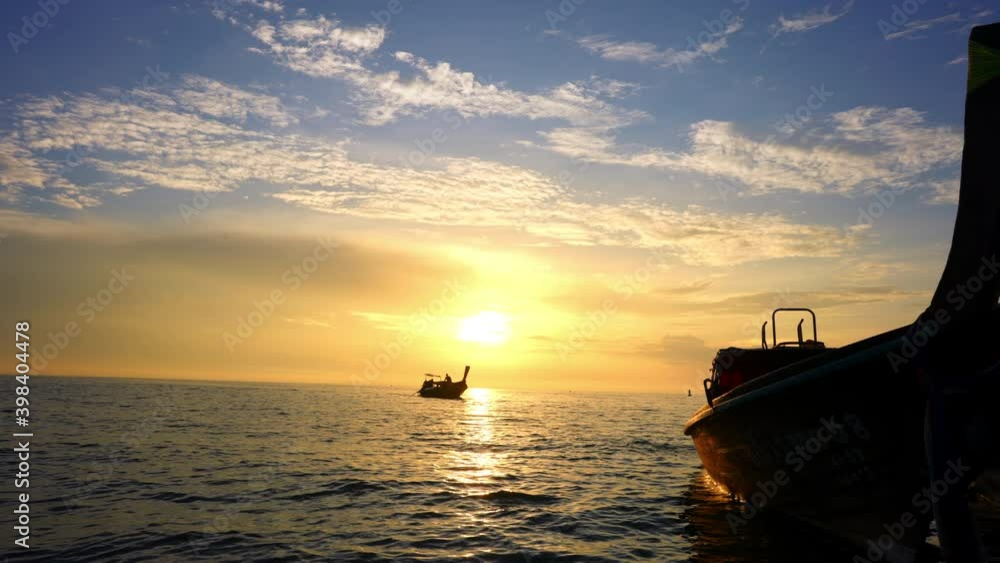 4K silhouette of passenger boat floating in the sea with golden reflections glitter of sunlight on waving sea water with dawn sky and cloud at summer sunrise. Freedom and holiday vacation concept. 4K silhouette of passenger boat floating in the sea with golden reflections glitter of sunlight on waving sea water with dawn sky and cloud at summer sunrise. Freedom and holiday vacation concept.