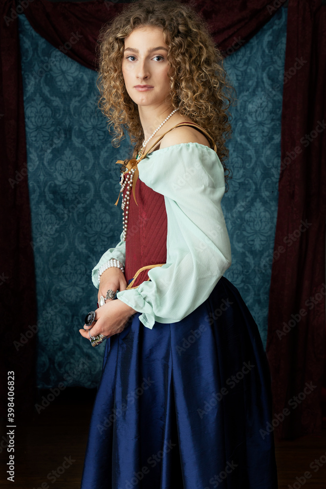 A young renaissance woman wearing a red corset and blue silk skirt