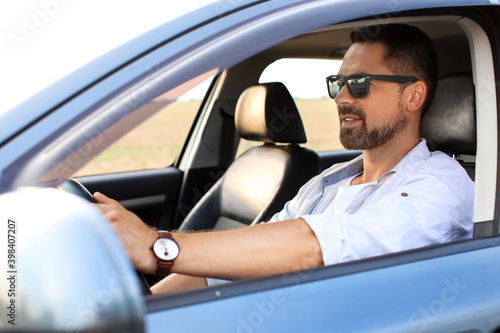 Handsome man driving modern...