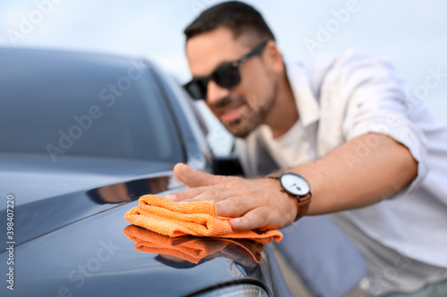 Handsome man washing his ca...