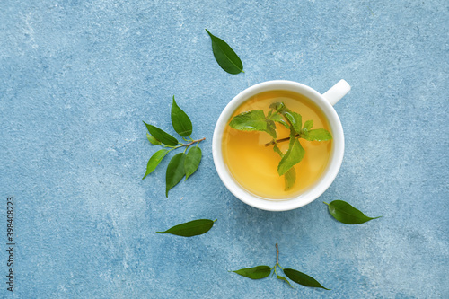 Cup of green tea on color background