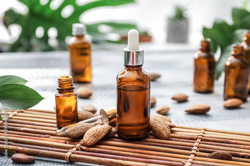 Bottles of almond essential oil on table