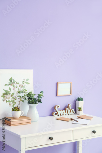 Stylish workplace with blank photo frame near color wall © Pixel-Shot
