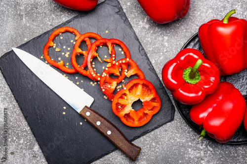 Red bell pepper and knife on dark background