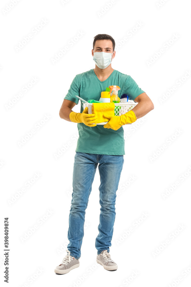 Young man in medical mask and with cleaning supplies on white background Young man in medical mask and with cleaning supplies on white background