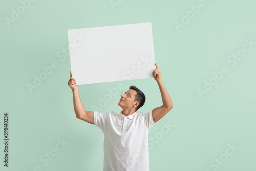 Young man with blank poster...