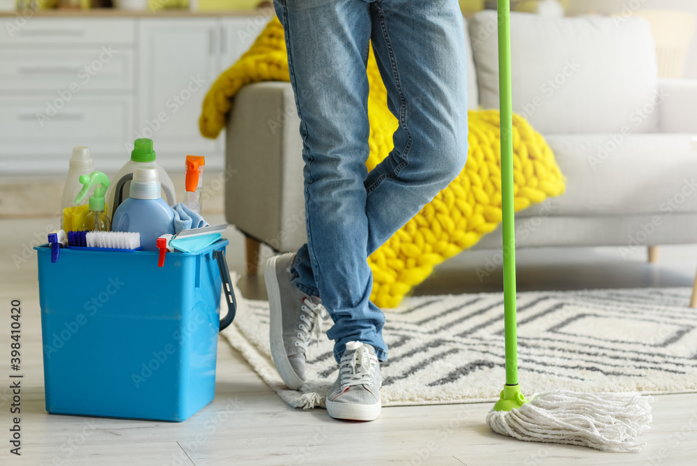 Young man with cleaning supplies at home Young man with cleaning supplies at home